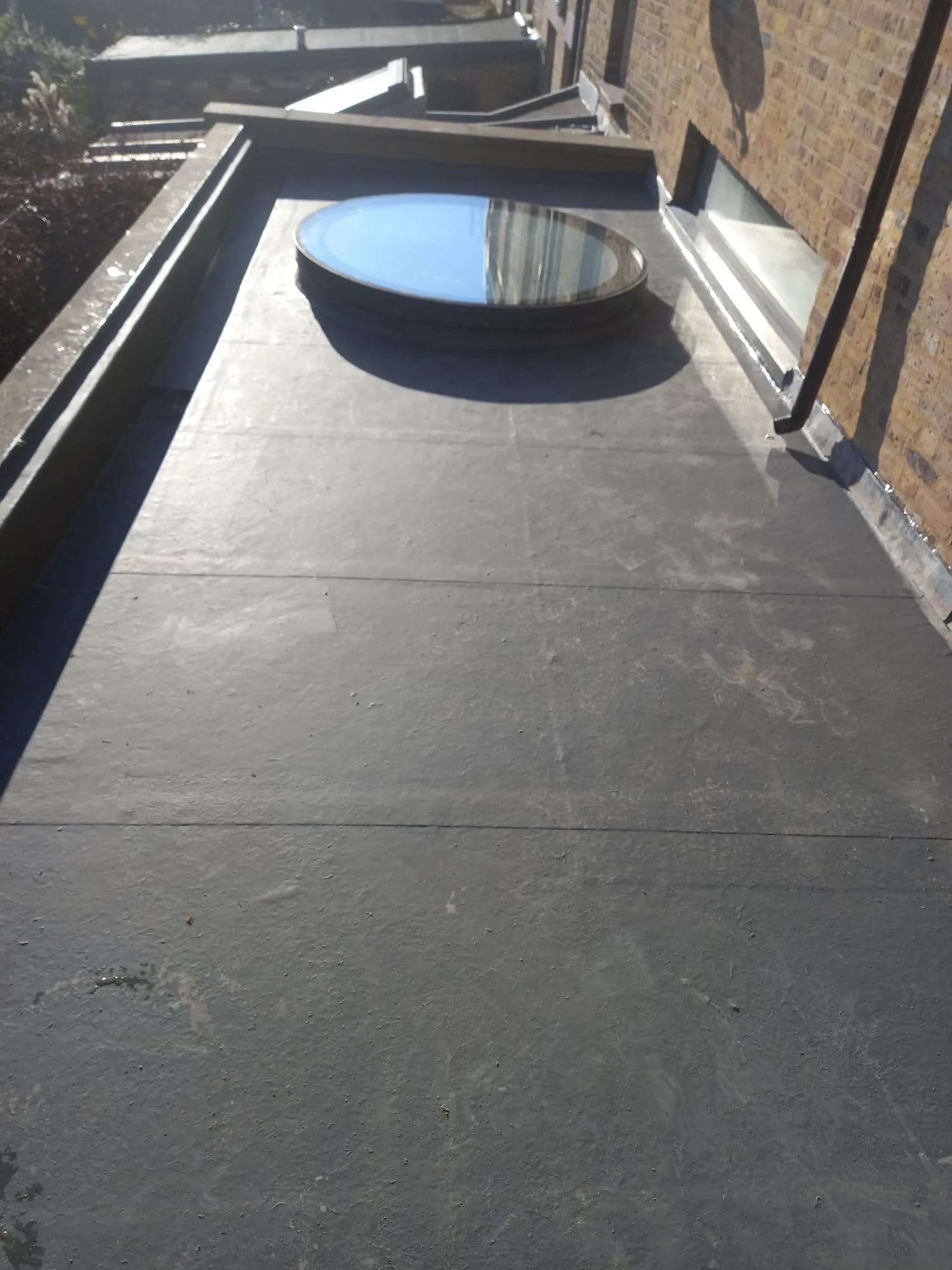 Concrete roof tiles with new black guttering on London terraced house