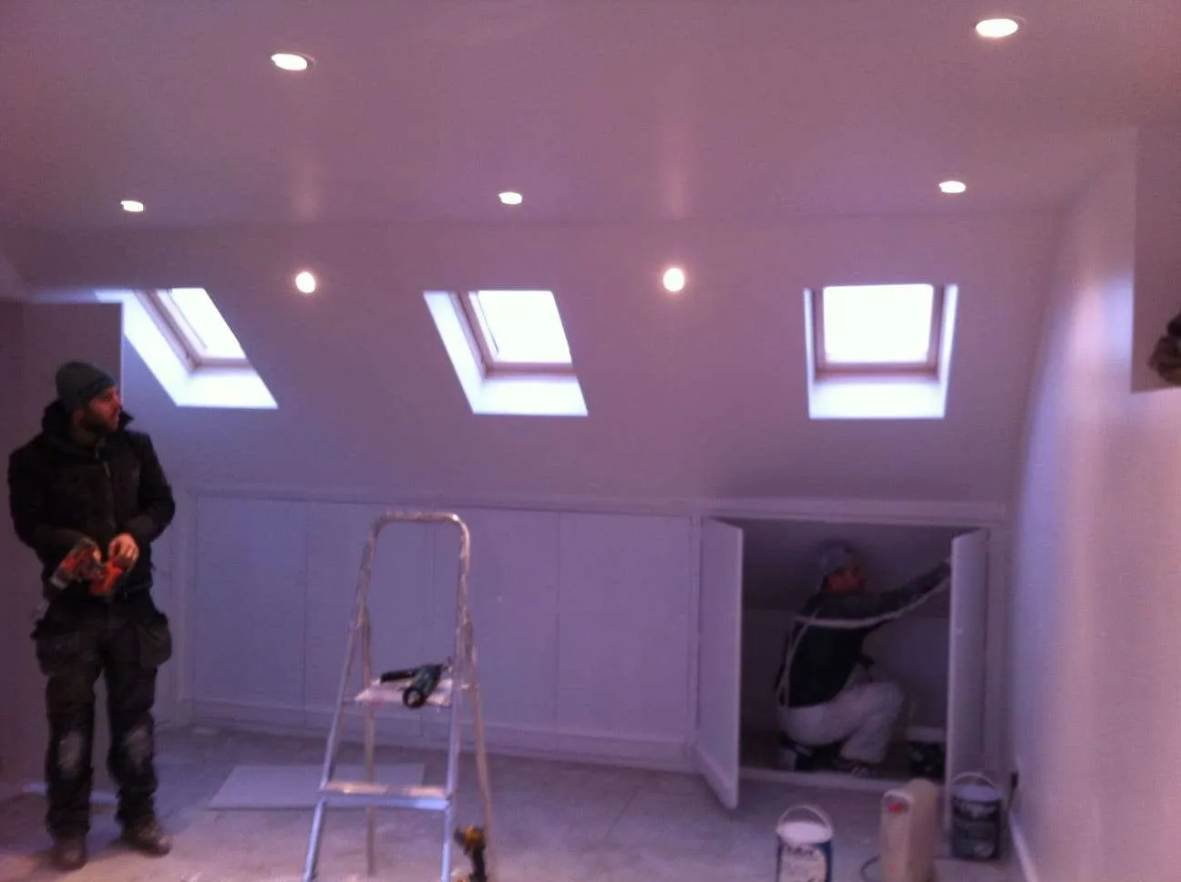 AC Roofing team fitting built-in storage in loft conversion with Velux windows