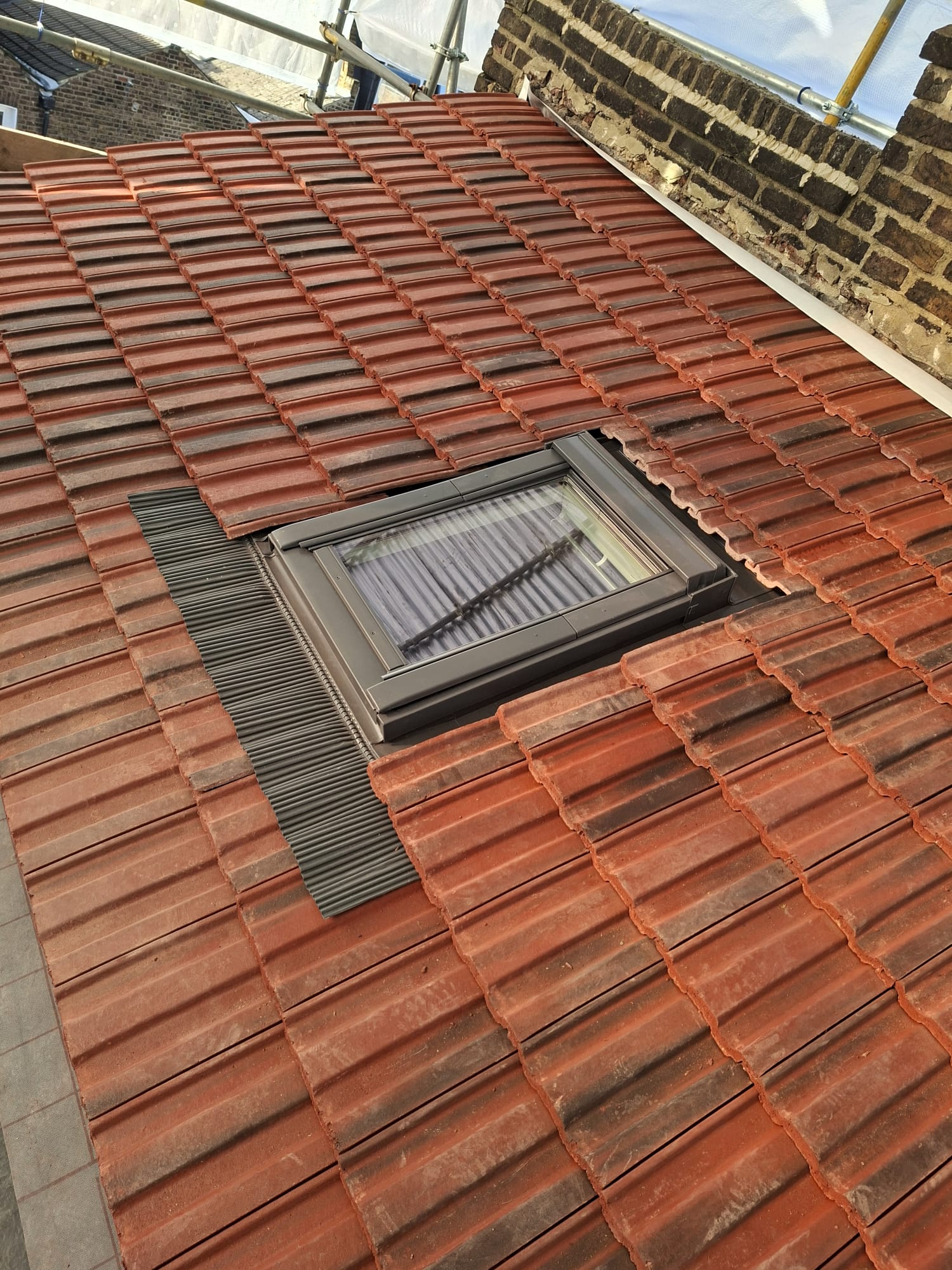 Close-up of Velux window flashing detail on clay tile roof